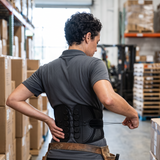 Worker adjusting the cord tensioners of the lumbar belt