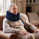 Older man relaxing at home with the neck traction device